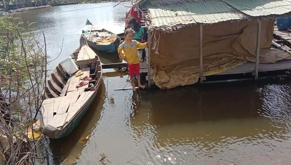 A girl outside her family's floating home on the water