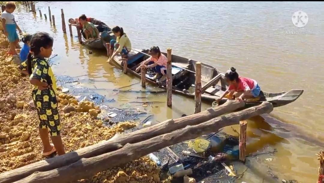 Children working at the water's edge in the village