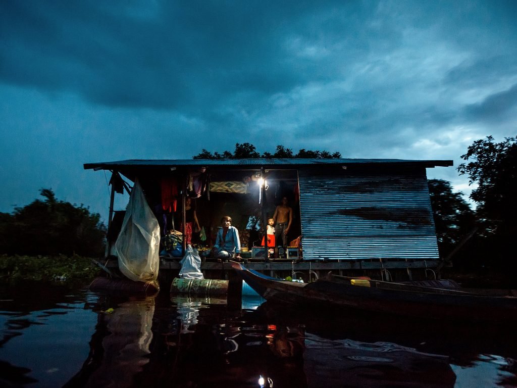 A floating shop at dusk in Chong Koh, photographed by Andrea Frazzetta for The New York Times