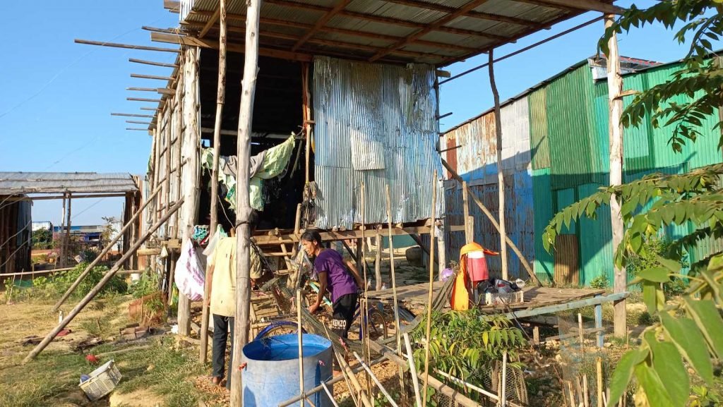 The Hoang family stilt house — built of corrugated metal and bamboo with washing hanging from the supports — where the children of the IHM school live