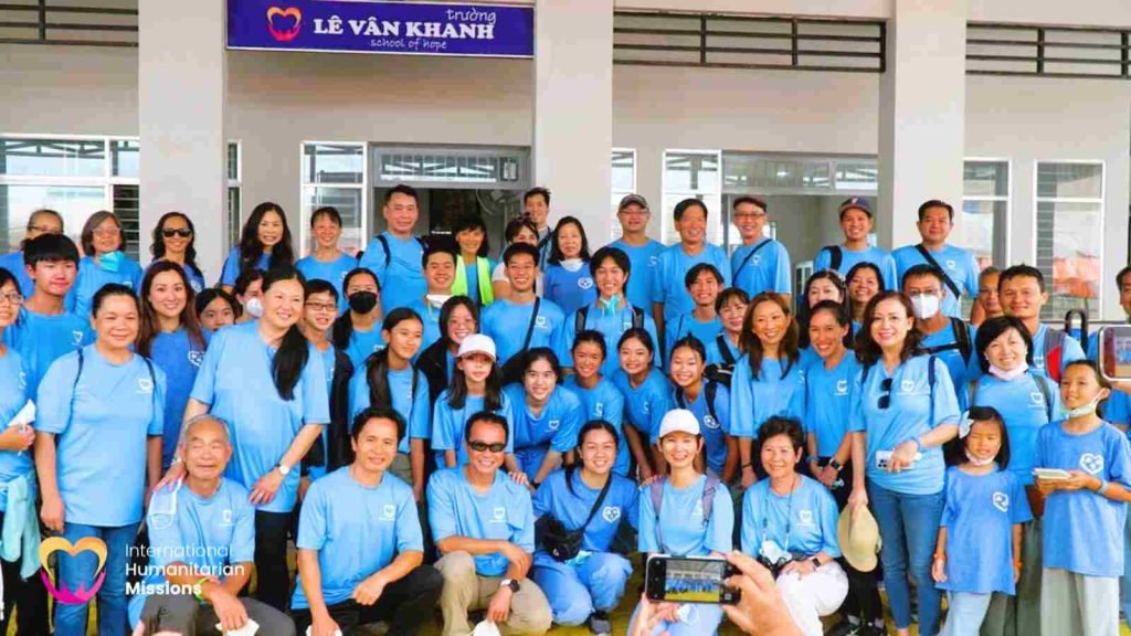 The IHM team gathered in front of the Le Van Khanh School of Hope sign